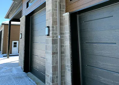 Gouttières noires sur une maison avec porte de garage