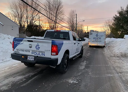 Camionnette Les Gouttières Poulin sur une rue de Terrebonne au coucher du soleil